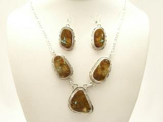 Genuine Boulder Turquoise set in Sterling Silver. This Beautiful Set includes the Necklace and Earrings. The photo is of the necklace and earrings you will be receiving. Created by Navajo Artist John Nelson. Signed. The cabochons are Boulder Turquoise, you can see the veins of Turquoise running through the host rock. The Boulder Turquoise Mine is located in northeast Nevada. It was discovered in 1970 by a Shoshone sheep herder. Production is small due to the remote location and winter weather. Boulder Turquoise is valued for both it's beauty and rarity. 