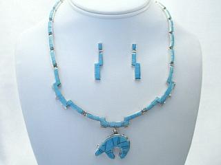 Authentic Native American Jewelry. Genuine Sleeping Beauty Turquoise inlaid between ribbons of Sterling Silver. Beautiful Bear Design. Necklace and Earrings Set with Sterling Silver Clasp. Created by Navajo Artist Calvin Begay. 
