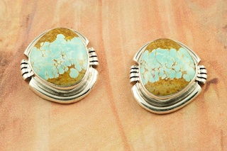 Genuine Number 8 Mine Turquoise Stones set in Sterling Silver Post Earrings. The Number 8 mine is located in Eureka County Nevada. Since 1976 there has been no Number 8 Turquoise mined. There is however, an existing stock pile that Mr. Dowell Ward, the last owner of the Number 8 mine, had stocked away for later sorting. The Turquoise is a collector's item--because once the reserve is gone there will be no more material released onto the market. The Gold Mining Company owns the claim to the Number 8 mine and it has been swallowed up by the gold mining operations. This is some of the last Number 8 Turquoise to be had and will be a great addition to your collection. Created by Navajo Artist Arkie Nelson. Signed by the artist. 
