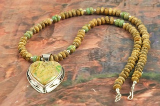 Stunning Pendant and Necklace Set featuring Genuine Boulder Turquoise set in Sterling Silver. The cabachon is Boulder Turquoise,you can see the veins of Turquoise running through the host rock. The Boulder Turquoise Mine is located in northeast Nevada. It was discovered in 1970 by a Shoshone sheep herder. Production is small due to the remote location and winter weather. Boulder Turquoise is valued for both it's beauty and rarity. Every stone is unique. Created by Navajo Artist Phillip Sanchez. Signed by the artist.