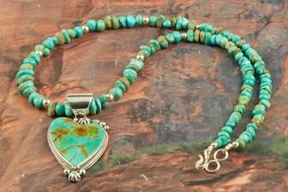 Stunning Pendant and Necklace Set featuring Genuine Manassa Turquoise set in Sterling Silver. This Turquoise is also referred to as King�s Manassa Turquoise. The Manassa Turquoise mine is located in Manassa, Conejos County, Colorado. Created by Navajo Artist Lucy Valencia. Signed L. J. by the artist.