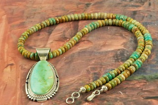 Stunning Pendant and Necklace Set featuring Genuine Royston Turquoise set in Sterling Silver. The Royston Turquoise Mine was originally known as the Royal Blue Mine. It produces Turquoise that has a mixture of blues and greens in the same formation. The Royston Turquoise Mine is located in Nye County, Nevada. Created by Navajo Artist Freddy Charley. Signed by the artist.
