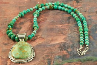 Stunning Pendant and Necklace Set featuring Genuine Royston Turquoise set in Sterling Silver. The Royston Turquoise Mine was originally known as the Royal Blue Mine. It produces Turquoise that has a mixture of blues and greens in the same formation. The Royston Turquoise Mine is located in Nye County, Nevada. Created by Navajo Artist Freddy Charley. Signed by the artist.