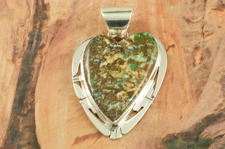 Genuine Sunnyside Turquoise set in Sterling Silver Pendant. Created by Navajo Artist Phillip Sanchez. Signed by the artist. The matrix on this rare stone is outstanding. The Sunnyside mine is located in northern Nevada near the town of Tuscarora in the Tuscarora mountain range. Free 18 inch Sterling Silver Chain with purchase of pendant.