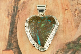 Genuine Sunnyside Turquoise set in Sterling Silver Pendant. Created by Navajo Artist Kathy Yazzie. Signed by the artist. The matrix on this rare stone is outstanding. The Sunnyside mine is located in northern Nevada near the town of Tuscarora in the Tuscarora mountain range. Free 18 inch Sterling Silver Chain with purchase of pendant.