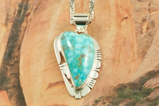 Genuine High Grade Kingman Web Turquoise set in Sterling Silver Pendant. Created by Navajo Artist Phillip Sanchez. Signed by the artist. The Mineral Park Mine, in the Cerbat Mountains 14 miles northwest of Kingman, was first mined by Indians centuries before white man came to the area. It is one of the three sites of prehistoric mining localities in the state of Arizona. Mineral Park was the most extensively worked area by the Indians of the three. S.A. �Chuck� Colbaugh found a cache of stone hammers uncovered in ancient trenches and tunnels, when he had the turquoise mining concession in May of 1962. Ithaca Peak and Turquoise Mine (formally called Aztec Mountain or Aztec Peak) are the most famous of the peaks in the area containing turquoise. Free 18