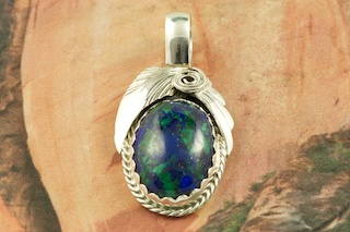 Genuine Azurite set in Sterling Silver Pendant. Azurite is mined at the Nevada Lode Mine, San Juan County, Utah. Created by Navajo Artist Justin Morris. Signed by the artist. Justin Morris incorporates meaning in his Sterling Silver Designs. The Sterling Silver Feather represents Life, the Shell represents Protection, the Circle of Life represents Balance. Free 18