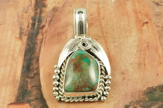Genuine Royston Turquoise set in Sterling Silver Pendant. Free 18 inch Sterling Silver Chain with purchase of pendant. Royston Turquoise Mine was originally known as the Royal Blue Mine. It produces Turquoise that has a mixture of blues and greens in the same formation. The Royston Turquoise Mine is located in Nye County, Nevada. Created by Navajo Artist Justin Morris. Signed by the artist. Justin Morris incorporates meaning in his Sterling Silver Designs. The Sterling Silver Feather represents Life, the Circle of Life represents Balance and the Raindrops represent Abundance.