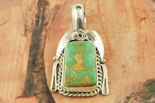 Genuine Pilot Mountain Turquoise set in Sterling Silver Pendant. Free 18 inch Sterling Silver Chain with purchase of pendant. The Pilot Mountain mine is located in Esmeralda County, Nevada. Created by Navajo Artist Justin Morris. Signed by the artist. Justin Morris incorporates meaning in his Sterling Silver Designs. The Sterling Silver Feather represents Life, the Circle of Life represents Balance and the Raindrops represent Abundance.