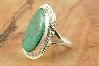 Genuine High Grade Kingman Web Turquoise set in Sterling Silver Ring. Created by Navajo Artist John Nelson. Signed by the artist. The Mineral Park Mine, in the Cerbat Mountains 14 miles northwest of Kingman, was first mined by Indians centuries before white man came to the area. It is one of the three sites of prehistoric mining localities in the state of Arizona. Mineral Park was the most extensively worked area by the Indians of the three. S.A. �Chuck� Colbaugh found a cache of stone hammers uncovered in ancient trenches and tunnels, when he had the turquoise mining concession in May of 1962. Ithaca Peak and Turquoise Mine (formally called Aztec Mountain or Aztec Peak) are the most famous of the peaks in the area containing turquoise.