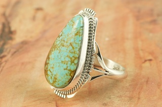 Genuine Number 8 Turquoise set in Sterling Silver Ring. The Number 8 mine is located in Eureka County Nevada. Since 1976 there has been no Number 8 Turquoise mined. There is however, an existing stock pile that Mr. Dowell Ward, the last owner of the Number 8 mine, had stocked away for later sorting. The Turquoise is a collector's item--because once the reserve is gone there will be no more material released onto the market. The Gold Mining Company owns the claim to the Number 8 mine and it has been swallowed up by the gold mining operations. This is some of the last Number 8 Turquoise to be had and will be a great addition to your collection. Created by Navajo Artist Kathy Yazzie. Signed by the artist.