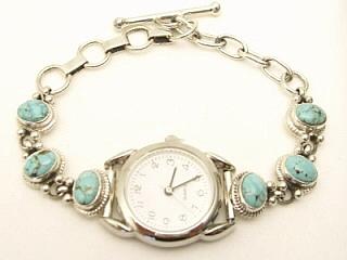 Genuine Number 8 Mine Turquoise set in Sterling Silver. Ladies Watch Bracelet Created by Navajo Artist Henry Begay. The Number 8 mine is located in Eureka County Nevada. Since 1976 there has been no Number 8 Turquoise mined. There is however, an existing stock pile that Mr. Dowell Ward, the last owner of the Number 8 mine, had stocked away for later sorting. The Turquoise is a collector's item--because once the reserve is gone there will be no more material released onto the market. The Gold Mining Company owns the claim to the Number 8 mine and it has been swallowed up by the gold mining operations. This is some of the last Number 8 Turquoise to be had and will be a great addition to your collection.  