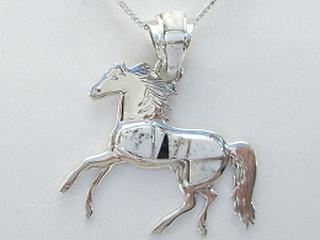 Authentic Native American Jewelry. White Buffalo Turquoise and Jet inlaid between ribbons of Sterling Silver. Stunning Horse Pendant. This Beautiful Stone is formed from the mineral Magnesite. It is mined near Elko Nevada. Created by Navajo Artist Calvin Begay and Pam Daniels. Free 18 