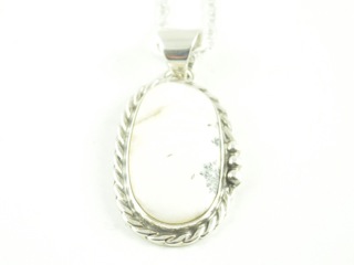White Buffalo Turquoise and Jet inlaid between ribbons of Sterling Silver. Stunning Bear Pendant. This Beautiful Stone is formed from the mineral Magnesite. It is mined near Elko Nevada. Created by Navajo Artist Calvin Begay. Free 18 " Sterling Silver Chain with purchase of pendant. 