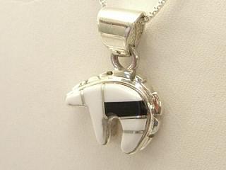 Genuine White Buffalo Turquoise and Black Jade inlaid between ribbons of Sterling Silver. Stunning Bear Pendant. This Beautiful Stone is formed from the mineral Magnesite. It is mined near Elko Nevada. Designed by Navajo Artist Calvin Begay. Free 18 