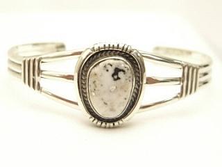 White Buffalo Turquoise Set in heavy gauge Sterling Silver. This Beautiful Stone is formed from the minerals Calcite and Iron. It is mined near Tonopah Nevada. Created by Navajo Artist Emerson Delgarito. Signed.
