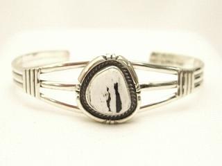 White Buffalo Turquoise Set in heavy gauge Sterling Silver. This Beautiful Stone is formed from the minerals Calcite and Iron. It is mined near Tonopah Nevada. Created by Navajo Artist Emerson Delgarito. Signed.

