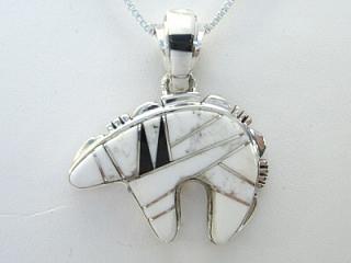 Authentic Native American Jewelry. White Buffalo Turquoise and Jet inlaid between ribbons of Sterling Silver. Stunning Bear Pendant. This Beautiful Stone is formed from the mineral Magnesite. It is mined near Elko Nevada. Created by Navajo Artist Calvin Begay and Olson Charleston. Free 18 