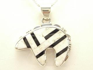 White Buffalo Turquoise and Jet inlaid between ribbons of Sterling Silver. Stunning Bear Pendant. This Beautiful Stone is formed from the mineral Magnesite. It is mined near Elko Nevada. Created by Navajo Artist Calvin Begay. Free 18 