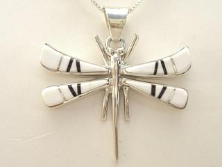 Authentic Native American Jewelry. White Buffalo Turquoise and Jet inlaid between ribbons of Sterling Silver. Beautiful Dragonfly Pendant. This Beautiful Stone is formed from the mineral Magnesite. It is mined near Elko Nevada. Created by Navajo Artist Calvin Begay and Olson Charleston. Free 18 