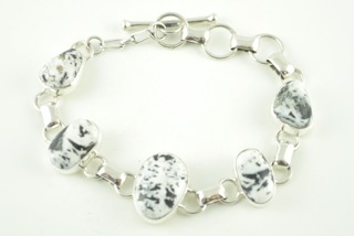 5 Beautiful White Buffalo Turquoise Stones set in Sterling Silver Link Bracelet. This Beautiful Stone is formed from the minerals Calcite and Iron. It is mined near Tonopah Nevada. This Beautiful Bracelet is a one of a kind Bracelet. The photo is of the jewelry you will be receiving. Created by Navajo Artist Tony Garcia. Signed.