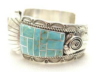 Genuine Sleeping Beauty Turquoise inlaid between ribbons of Sterling Silver. Watch bracelet features beautiful Sterling Silver detail. Created by Navajo Artist Nelson Chicharello. 