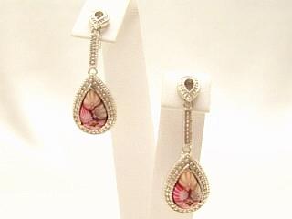 Millefiori Drop Earrings A multi color Millefiroi oval glass detail hand set in a nickel free sterling silver earring frame. Millefiori is a type of Murano glass that has been incorporated with various layers of colors to create beautiful flower-like patterns. Millefiori, which literally means �a thousand flowers�, is the denomination of a type of cylindrical, long glass rod which contains a specific pattern along its entire length, so that when cut into slices from one end, the particular pattern will be revealed. It is completely handmade of authentic Murano glass. This style of glass has been around since the Middle Ages and more recently, has been produced for fine jewelry.