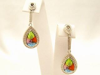 Millefiori Drop Earrings A multi color Millefiroi oval glass detail hand set in a nickel free sterling silver earring frame. Millefiori is a type of Murano glass that has been incorporated with various layers of colors to create beautiful flower-like patterns. Millefiori, which literally means �a thousand flowers�, is the denomination of a type of cylindrical, long glass rod which contains a specific pattern along its entire length, so that when cut into slices from one end, the particular pattern will be revealed. It is completely handmade of authentic Murano glass. This style of glass has been around since the Middle Ages and more recently, has been produced for fine jewelry.