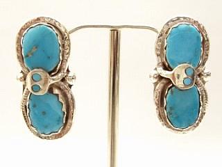 Genuine Turquoise set in Sterling Silver Post Earrings. Created by Zuni Artist Effie Calavaza. A signature trademark of Effie's is the snake symbol, entwined around Turquoise on Sterling Silver. Signed Effie C. Zuni.