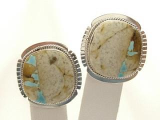 Genuine Boulder Turquoise set in Sterling Silver Clip on Earrings. The cabachons are of Boulder Turquoise, you can see the veins of Turquoise running through the host rock. The Boulder Turquoise Mine is located in northeast Nevada. It was discovered in 1970 by a Shoshone sheep herder. Production is small due to the remote location and winter weather. Boulder Turquoise is valued for both it's beauty and rarity. Every stone is unique. Created by Navajo Artist Bobby Piaso. Signed BP.