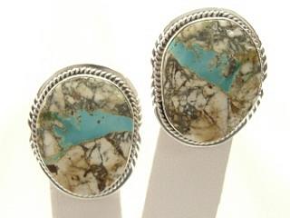 Genuine Boulder Turquoise set in Sterling Silver Clip on Earrings. The cabachons are of Boulder Turquoise, you can see the veins of Turquoise running through the host rock. The Boulder Turquoise Mine is located in northeast Nevada. It was discovered in 1970 by a Shoshone sheep herder. Production is small due to the remote location and winter weather. Boulder Turquoise is valued for both it's beauty and rarity. Every stone is unique. Created by Navajo Artist Lucy Valencia. Signed LJ.