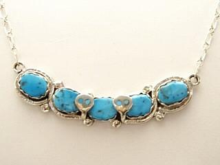 Created by Zuni Artist Effie Calavaza. A signature trademark of Effie's is the snake symbol, entwined around Turquoise on Sterling Silver.  