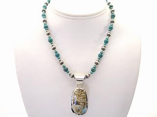 Genuine Boulder Turquoise set in Sterling Silver Pendant, on a Genuine Turquoise Necklace. Sterling Silver Toggle Clasp. The cabochon is Boulder Turquoise, you can see the veins of Turquoise running through the host rock. The Boulder Turquoise Mine is located in northeast Nevada. It was discovered in 1970 by a Shoshone sheep herder. Production is small due to the remote location and winter weather. Boulder Turquoise is valued for both it's beauty and rarity. Every stone is unique. Created by Navajo Artist Phillip Sanchez. Signed.