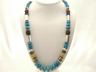 Assorted Genuine Gemstones Necklace with Sterling Silver & Gold Fill Barrels. Sterling Beads & Clasp. Featuring Genuine Turquoise, Coral, Jasper and Lapis. Created by Navajo Artist Tommy Singer. Signed T. Singer.