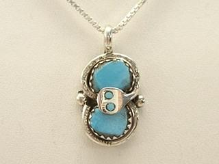Created by Zuni Artist Effie Calavaza. A signature trademark of Effie's is the snake symbol, entwined around Turquoise on Sterling Silver. 