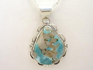 Genuine Royston Turquoise set in Sterling Silver Pendant. Beautiful Matrix in this Turquoise Stone. The Royston Turquoise Mine is located in Nye County, Nevada. Free 18" Sterling Silver Chain with Purchase of Pendant. Created by Navajo Artist Lexcey Billie. Signed LB.