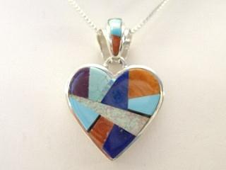 Genuine Turquoise, Spiny Oyster Shell, Lapis and Fire & Ice Lab Opal inlaid between ribbons of Sterling Silver. Heart Pendant. Beautiful channel inlay on the bale and pendant. Storyteller design in Sterling Silver on the back of the pendant. Free 18" Sterling Silver Chain with Purchase of Pendant. Calvin Begay Design.